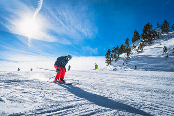 Man skiing down the ski slope or piste in Pyrenees Mountains. Winter ski holidays in El Tarter,...