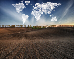 clouds in the form of a map of the world over the field. Travel and landscape concept. hilly field