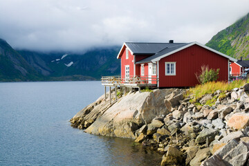 Traditionelles rotes Holzhaus an der Küste von Reinefjorden, Lofoten, Norwegen