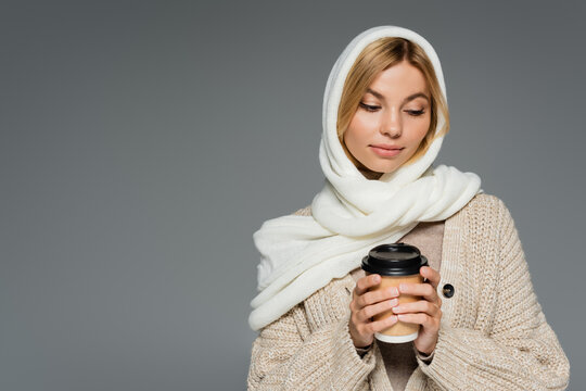 Young Woman In Winter Headscarf Holding Paper Cup With Takeaway Drink Isolated On Grey.