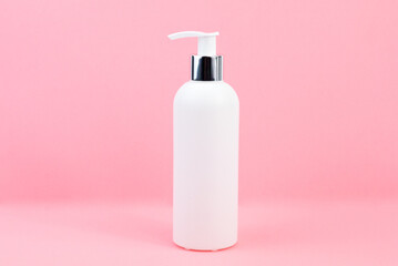 A white cosmetic bottles mockup. White plastic bottles with shampoo and conditioner and shower gel on a pink background. Mockup cosmetic bottle with place to add text on pink background