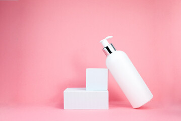 A white cosmetic bottles mockup. White plastic bottles with shampoo and conditioner and shower gel on a pink background. Mockup cosmetic bottle with place to add text on pink background