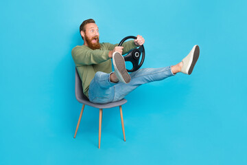 Full size photo of speechless man red hairstyle khaki pullover hold steering wheel trouble accident isolated on blue color background