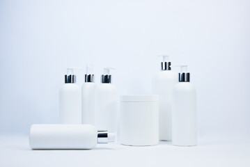 Set of white cosmetic bottles mockup. White plastic bottles with shampoo and conditioner and shower gel on a white background. Mockup cosmetic bottle with place to add text on white background