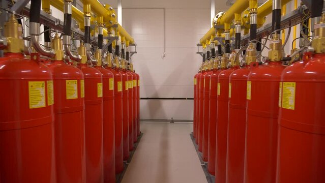 Modern industrial professional  fire extinguishing system. Rows of red metal cylinders of fire extinguishers in a special fire safety room. Fire prevention. Means for extinguishing fires.