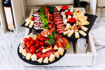 delicious table with different meat, cheese and tomatoes at wedd