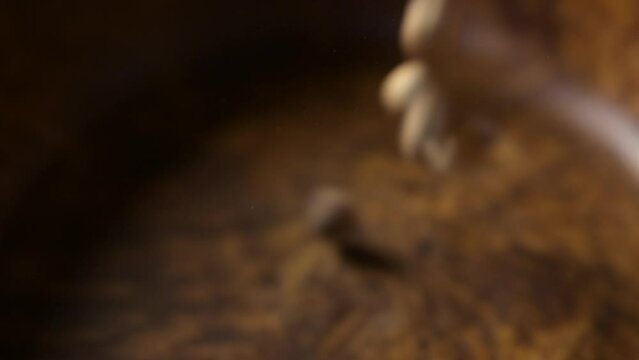 Hazelnuts Falling in a wooden bowl in rotation and in Slow Motion