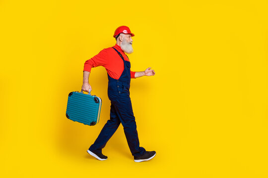 Profile side full length photo of professional technician go0 hold toolkit box isolated on shine color background