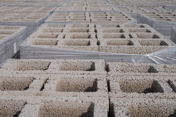 Close up to cement concrete building cinder blocks brick aligned on a construction site.