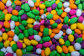 Fototapeta na wymiar Colorful sweet hard candy, mutitude of bombons in a bowl, texture of sugar covered candy in a lot of vibrant colors. Pills like looking candy.