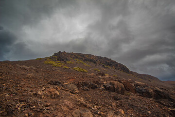 Paisaje volcanico de las Islas Canarias despues de una tormenta tropical en verano, arena y rocas negras de tipo volcanico un precioso mar con colores profundos y olas golpeando a las rocas