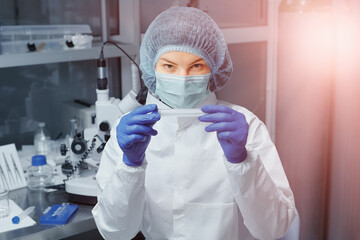 Scientist or nurse in a medical research laboratory is holding a test tube.