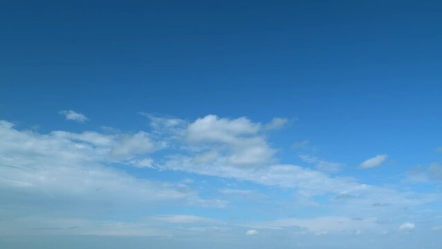Clouds move in the blue sky. Tropical sky at day time, only white and blue colors. Semi-transparent layers on different height. Timelapse.