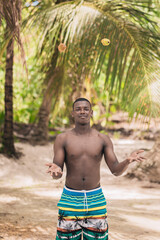 Black man juggling fruits on beach