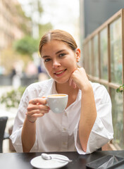 Portrait of elegant female who is enjoying coffee in cafe