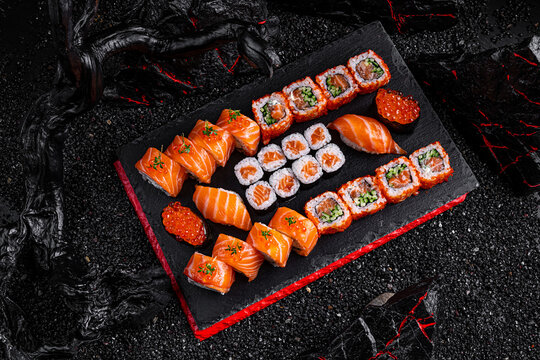 rolls set Hattori Hanzo. Philadelphia California salmon sushi salmon sushi with red caviar on a black background