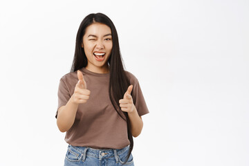 You got this, congrats. Smiling asian girl saluting, pointing fingers at camera, congratulating,...