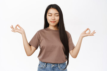Asian woman meditating, practice yoga, breathe with relaxed, resting face, standing over white...