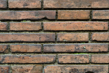 brick wall of red color, wide panorama of masonry. Old brick wall with shadow texture. cracked bricks, with a weathered and faded surface. Restored brickwork of an old house.