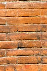 brick wall of red color, wide panorama of masonry. Old brick wall with shadow texture. cracked bricks, with a weathered and faded surface. Restored brickwork of an old house.