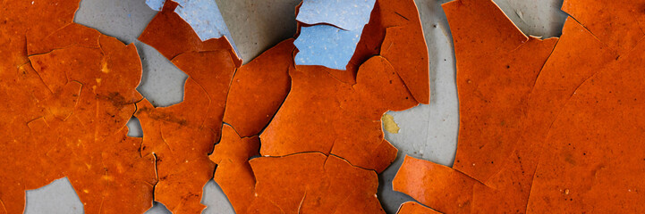 Peeling paint on the wall. Panorama of a concrete wall with old cracked flaking paint. Weathered rough painted surface with patterns of cracks and peeling. Wide panoramic texture for grunge background