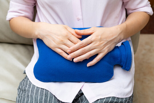 lady holding a hot water bag on the stomach