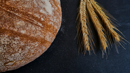 Ears and rustic bread covering a half of the area, selective focus and isolated photo.