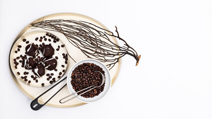 Chocolate chip cookies and black coffee grains on a dish on a white background