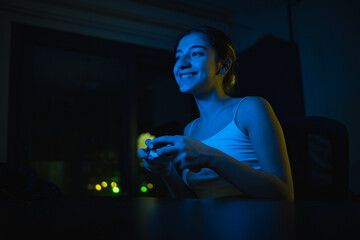 young gamer girl excitedly playing console game and winning and happy