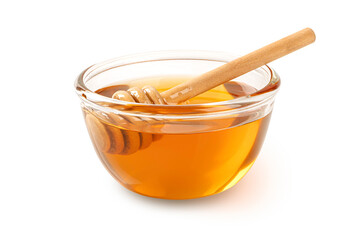 Honey in glass bowl and honey dipper on white background.