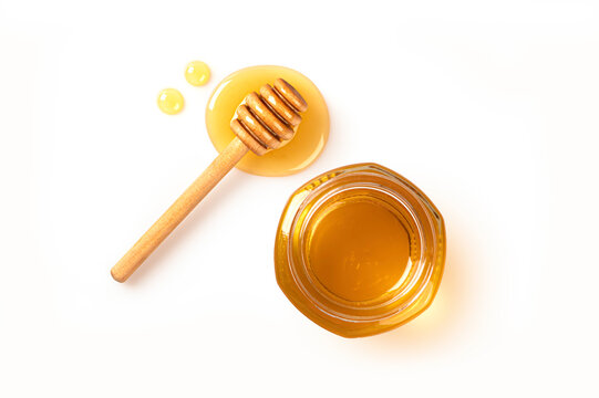 Honey jar with honey dripping isolated on white background. Top view