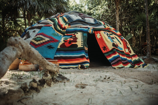 Traditional indigenous Maya sweating cabin in exotic white sand garden surrounded by tropical green forest on a sunny afternoon in Tulum