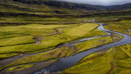 birdview of tundra field, rivers and clouds over mountain ridge