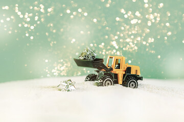 Close-up portait of a toy loader with christmas gifts in front of a festive glitter bokeh