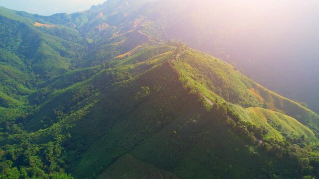 Drone fly over "Loi Fah Road", It is a beautiful country road and a famous tourist attraction. Nan, Thailand. high agricultural areas and tropical forest. green background in sunlight. travel concept
