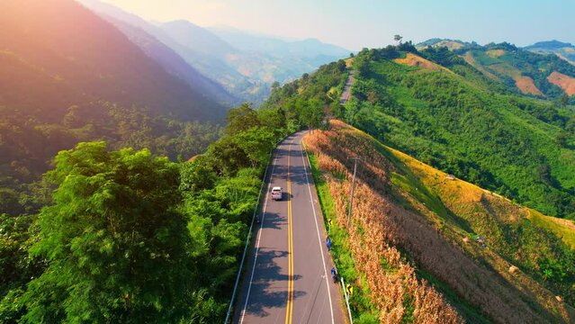 Drone fly over "Loi Fah Road", It is a beautiful country road and a famous tourist attraction. Nan, Thailand. high agricultural areas and tropical forest. green background in sunlight. travel concept

