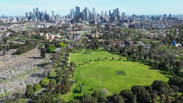 Flying over Princes park in Melbourne, Australia with the city skyline in background