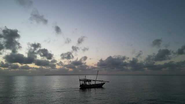 Boat floating near Uroa beach in Zanzibar Island, Tanzania Africa during sunset, Locked shot