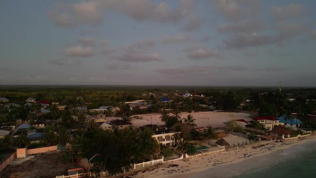 Sand soccer field and beachfront lodge in Uroa Beach Zanzibar Island, Tanzania Africa, Aerial pedestal rising shot
