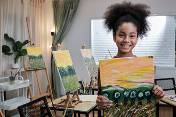 One Black student girl shows her painting work, proud with portfolio, acrylic color picture on...