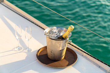 Champagne bottle in ice bucket with champagne glass on the tray for serving to passenger tourist on...