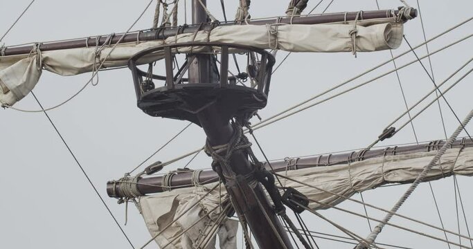 Galleon Andalucia replica ship detail tilt shot of forecastle mast and sail while docked in Valencia in slow motion 60fps