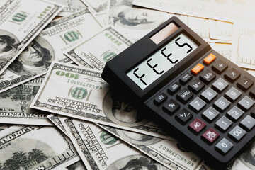 Calculator with the word FEES on the calculator placed on the dollar, concepts, fees, fees services...