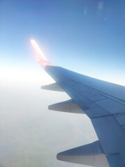 Fototapeta premium wing view of air India express Boeing 737 from airplane window. ntriguing view from inside an airplane, showcasing the wing's dynamic shape against the sky. Perfect for travel and aviation enthusiasts