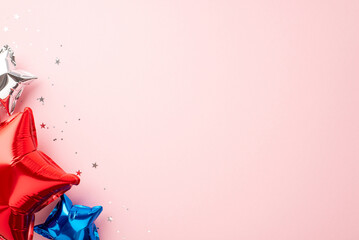 USA Independence Day celebration concept. Top view photo of star shaped balloons in national flag colors and shiny confetti on isolated pastel pink background with copyspace