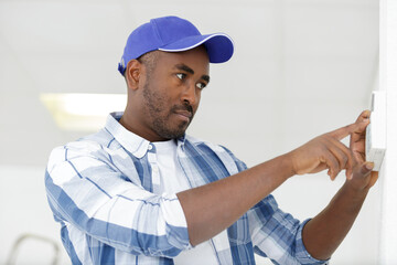a happy plumber fixing thermostat