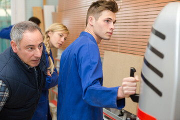 wood processing apprentice operating a machine