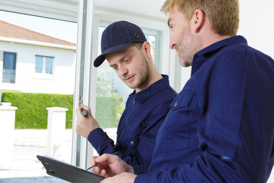 Portrait Of Workers Installing Sliding Glass Door