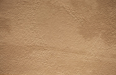 Brown background from decorative plaster with abstract spots. Unusual beige wall texture with beautiful patterns, creative surface background. Front covering for facing of buildings.