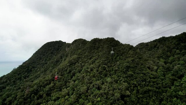 Langkawi SkyCab. Cable Cars Moving Above Mountains In Langkawi Island, Malaysia. wide aerial
